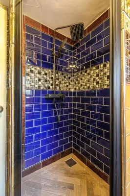 a blue tiled shower with a clear glass door at Luxury 3 Bed Manor House Hot Tub Cinema Room SkyTV in Saffron Walden