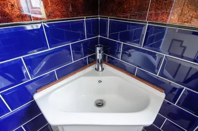 a bathroom with blue tiled walls and a sink at Luxury 3 Bed Manor House Hot Tub Cinema Room SkyTV in Saffron Walden