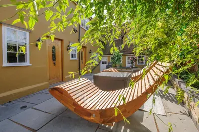 a wooden boat sitting outside of a house at Luxury 3 Bed Manor House Hot Tub Cinema Room SkyTV in Saffron Walden