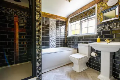 a bathroom with a sink and a toilet and a tub at Luxury 8 Bed Manor House Hot Tub Cinema Room SkyTV in Saffron Walden
