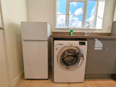 a kitchen with a washing machine and a refrigerator at 3-Bed, Sleeps 5, 3 Bath, Parking, WiFi in Watton