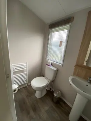 a bathroom with a toilet and a sink at VerbZen Holiday Caravan at St Osyth Beach, Clacton-on-Sea by Verb Holidays in Saint Osyth