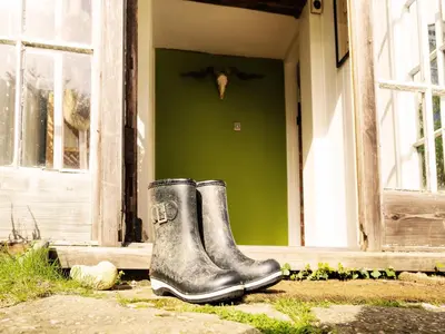 a pair of rubber boots sitting outside of a door at Prospect Place by The Suffolk Cottage Collection in Westleton