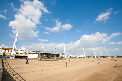 a group of people on a sandy beach at Spacious 3 Bedroom Home, Sleeps 7, Long-Stay & Contractor Friendly, Family & Professional Ready, Clark Property Estates in Southend-on-Sea