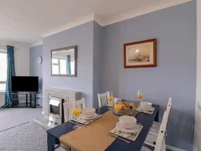 a living room with a table and a dining room at The Upper Circle in Clacton-on-Sea