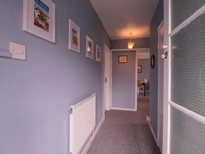 a hallway with blue walls and a white radiator at The Upper Circle in Clacton-on-Sea