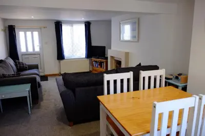 a living room with a couch and a table at Cosy Cottage to Relax or Explore in Mistley