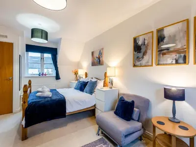 a bedroom with a bed and a chair at Bluebell Lodge in Longstowe