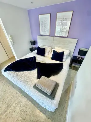 a bedroom with a large white bed with blue pillows at Cambridge City Centre Studio First Floor Sleeps 3 in Cambridge