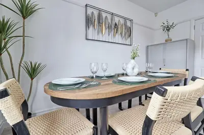 a dining room with a wooden table and chairs at High view house, 3 bed flat, Number 41A in Walton-on-the-Naze