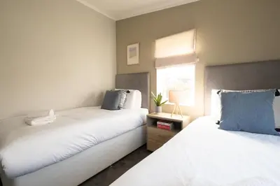a bedroom with two beds and a window at Pebbles - Church Farm - Aldeburgh Coastal Cottages in Aldeburgh