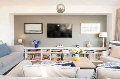 a living room with a couch and a tv at Pebbles - Church Farm - Aldeburgh Coastal Cottages in Aldeburgh