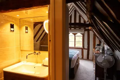 a bathroom with a sink and a bed in a room at The Oaksmere in Eye