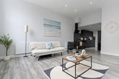 a living room with a couch and a table at Harwich Luxury Suite in Harwich