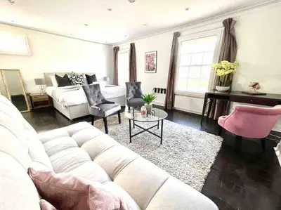 a living room with a white couch and a bed at Historical Police Station Building l Central Cambridge I Park View in Cambridge