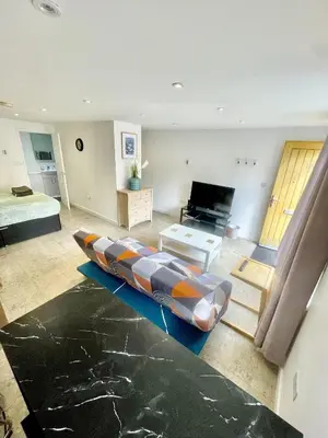 a large room with a bed and a large couch at Studio - Sleeps 2 - Parking - Wifi in Cambridge