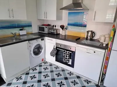 a kitchen with a washer and dryer in it at AcLand Lodge Dovercourt West in Harwich