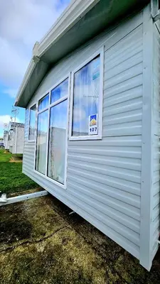 a building with a window with a sign on it at Pura Vida Caravan in Saint Osyth