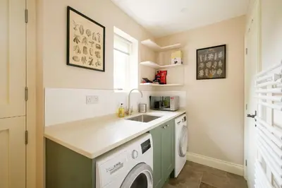 a laundry room with a sink and a washing machine at 9 The Haven in Thorpeness