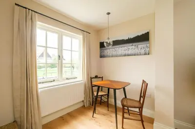 a dining room with a table and chairs and a window at 9 The Haven in Thorpeness