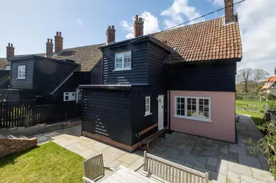 a black house with a patio in front of it at 9 The Haven in Thorpeness