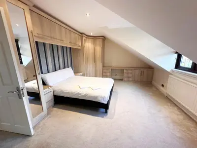 a attic bedroom with a bed and a window at Emerson Park Mansion in Harold Wood