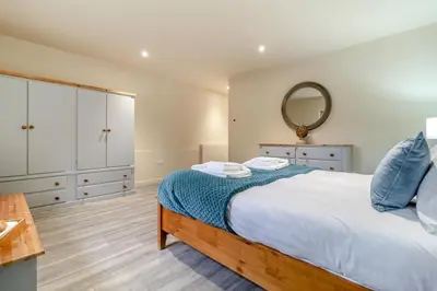 a bedroom with a large bed and a mirror at 1 Bed in Heveningham oc-w29032 in Heveningham