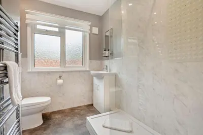a bathroom with a toilet and a sink and a window at 3 Bed in Acton oc-c28929 in Great Waldingfield