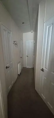 an empty hallway with two white doors in a room at 3 Bedroom caravan St osyth beach holiday park with free WiFi and parking in Great Clacton