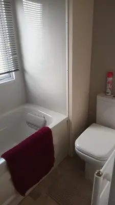 a bathroom with a white tub and a toilet at 3 Bedroom caravan St osyth beach holiday park with free WiFi and parking in Great Clacton