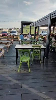 a group of picnic tables and chairs on a deck at 3 Bedroom caravan St osyth beach holiday park with free WiFi and parking in Great Clacton
