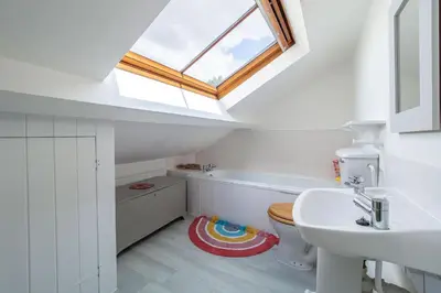 a bathroom with a toilet and a sink and a skylight at Foxhole Cottage 8 in Stowmarket