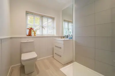 a white bathroom with a toilet and a sink at Foxhole Cottage 8 in Stowmarket