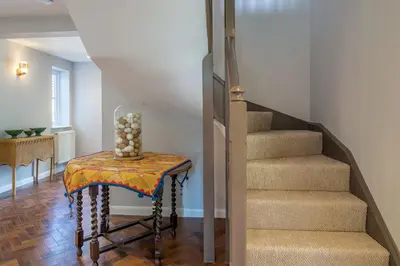 a stairway with a table with a vase on it at Foxhole Cottage 10 in Stowmarket