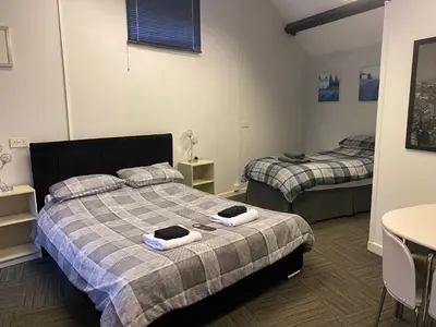 a bedroom with two beds and a table and a table at The Stables in Takeley