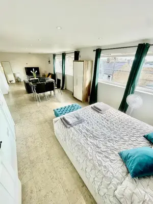 a bedroom with a large bed and a dining room at Studio - Sleeps 2 - Parking - Wifi in Cambridge