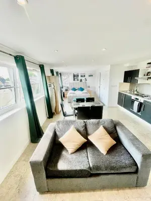 a living room with a couch and a kitchen at Studio - Sleeps 2 - Parking - Wifi in Cambridge