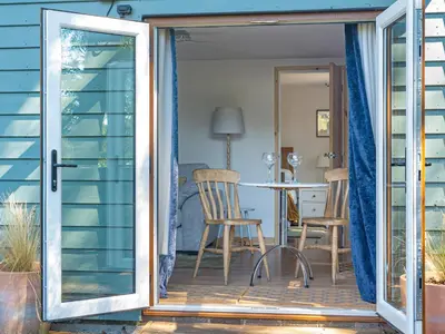 an open door to a patio with a table and chairs at Island Lodge - Uk46767 in Little Baddow