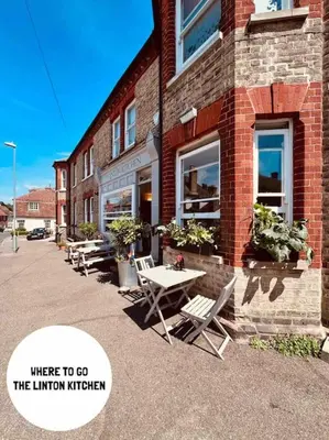 a group of tables and chairs outside of a brick building at The Hideout in Linton