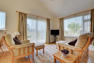 a living room with two chairs and a tv at 2 Bed in Attleborough oc-1277 in Old Buckenham