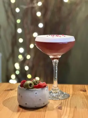 a drink in a martini glass sitting on a table at Mulberry Tree in Attleborough