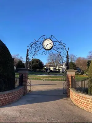 a gate with a clock on it in a park at Cosy Stylish house near Southend - Pass the Keys in Southend-on-Sea