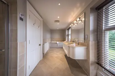 a bathroom with two sinks and a large mirror at Wivenhoe House Hotel in Colchester