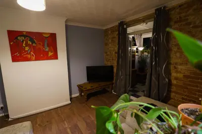 a living room with a couch and a painting on the wall at 3 Bedroom home by Ipswich docks. in Ipswich