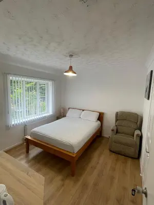 a bedroom with a bed and a chair in it at Welcoming Guesthouse in Cambridge