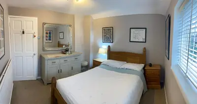 a bedroom with a bed and a sink and a mirror at relaxed and peaceful in St Ives