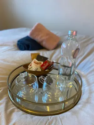 a tray with bowls and a bottle on a bed at relaxed and peaceful in St Ives