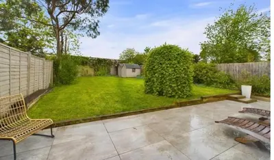 a backyard with a fence and a grass yard at relaxed and peaceful in St Ives