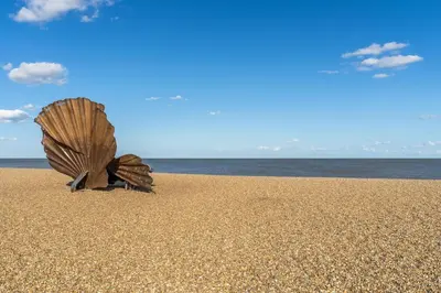 a shell in the sand on a beach at Marine Cottage in Aldeburgh