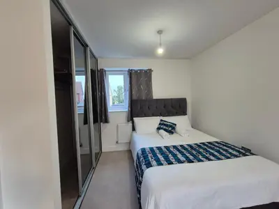 a small bedroom with a bed and a window at Double Room in a shared 4 bedroom family home in Broomfield in Chelmsford